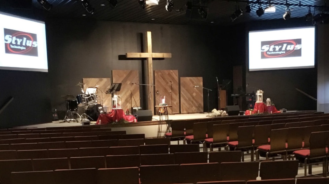 Church sanctuary with stage, cross, lighting and Stylus Technologies projection screens